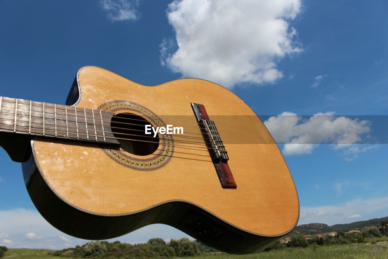 Low angle view of guitar against sky