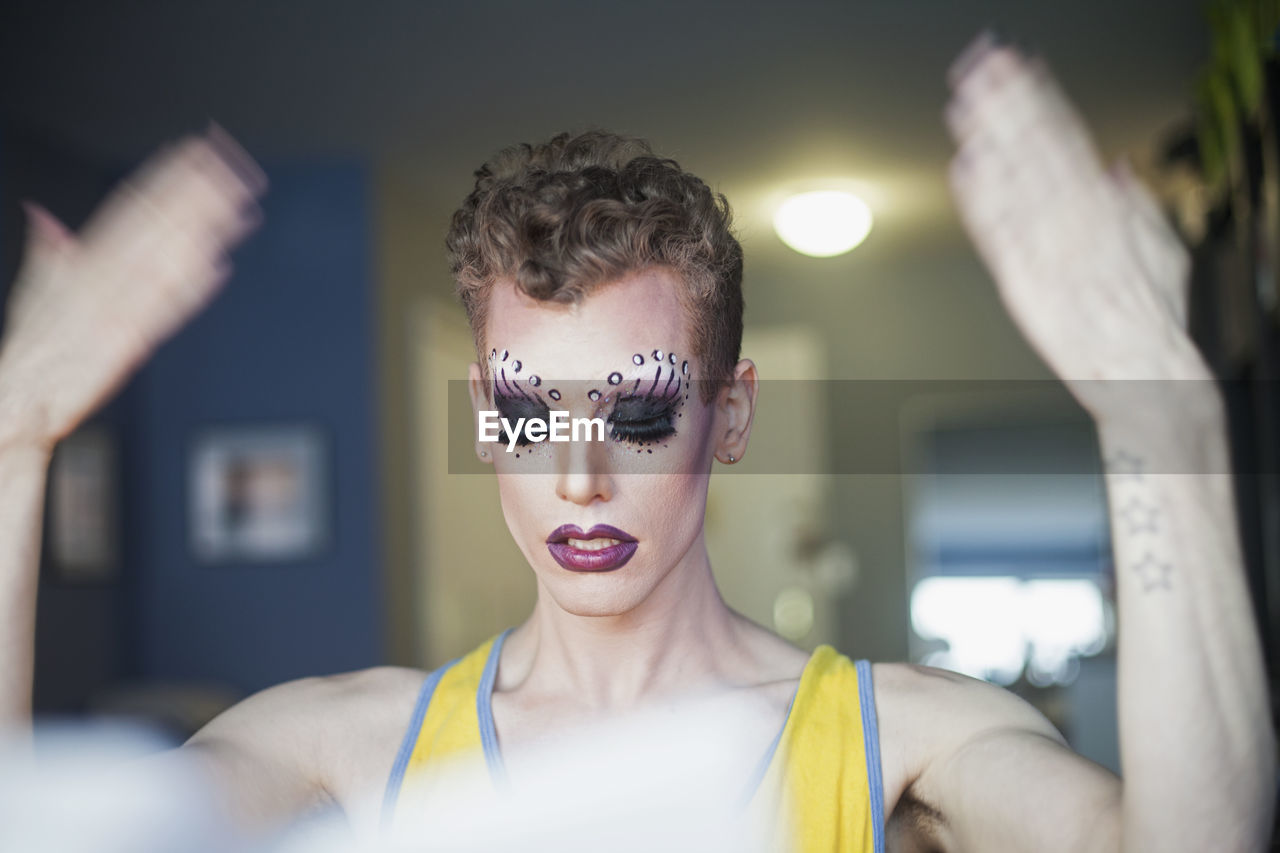 Young man letting drag makeup dry