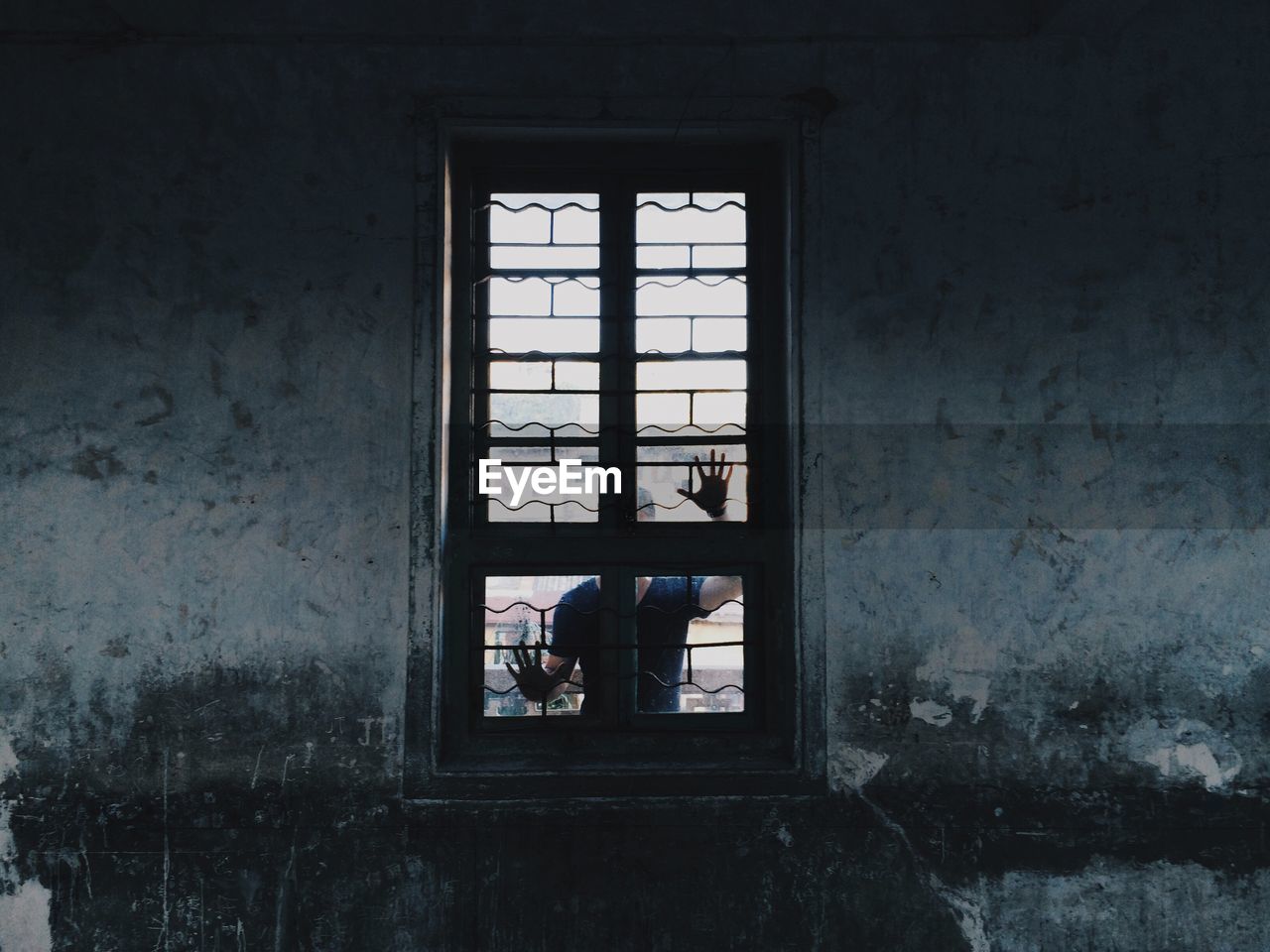 Man standing behind closed window