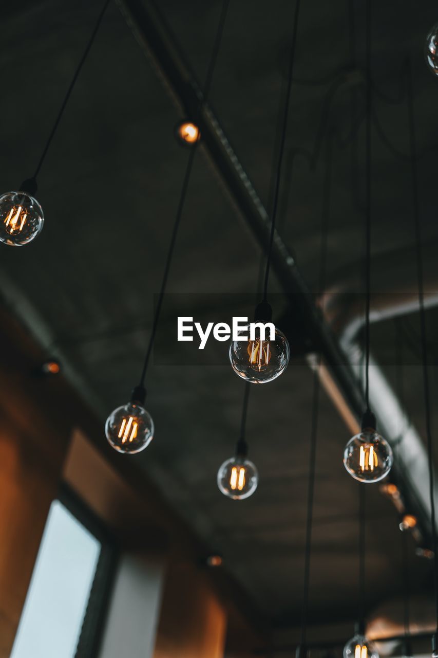 Low Angle View Of Illuminated Light Bulbs Hanging On Eyeem