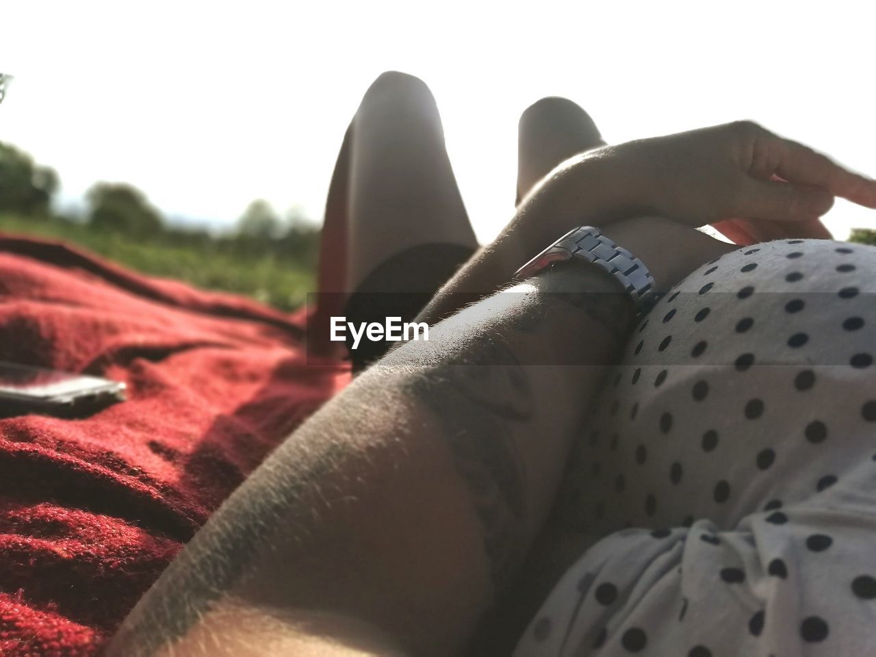 Cropped hand of man with girlfriend against sky