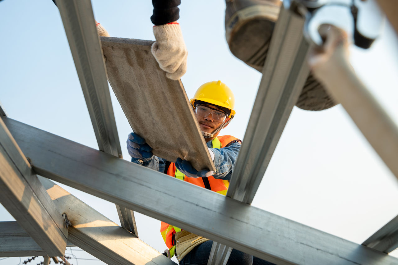 LOW ANGLE VIEW OF MEN WORKING ON CONSTRUCTION SITE