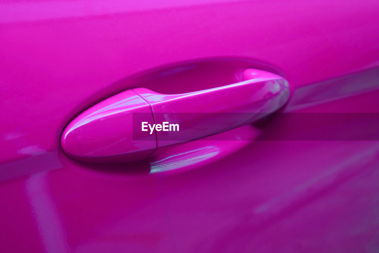 Closeup of vivid ultra pink car's door outside handle