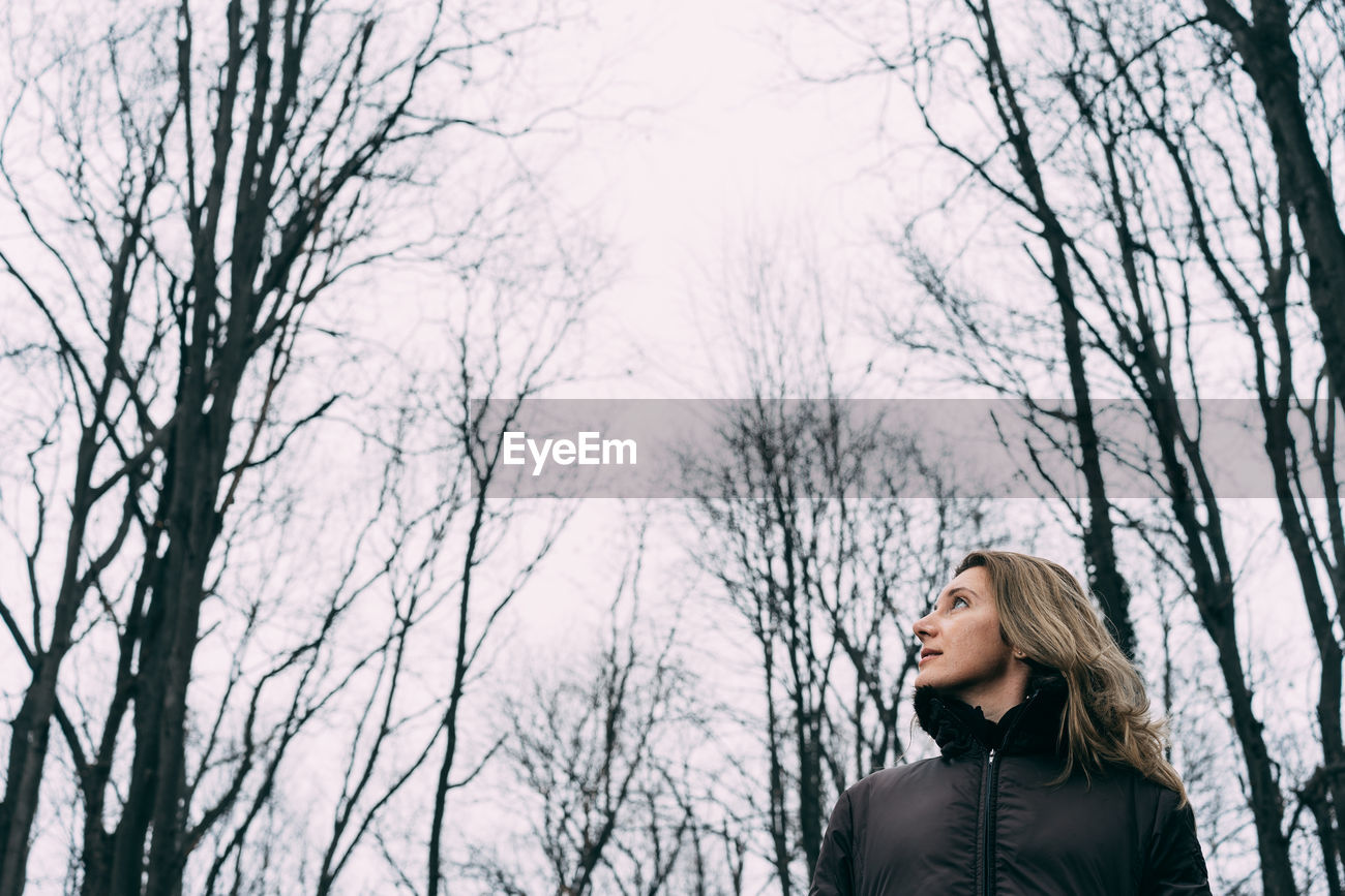 Woman Standing By Bare Trees In Winter Id 115372690