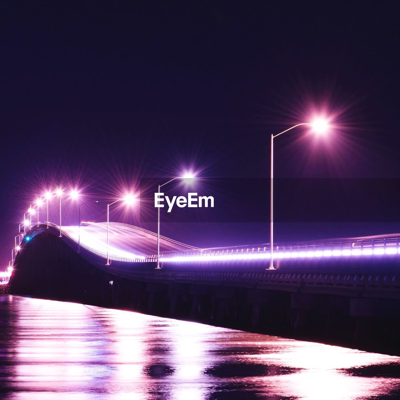 Light trails and illuminated street lights on bridge at night