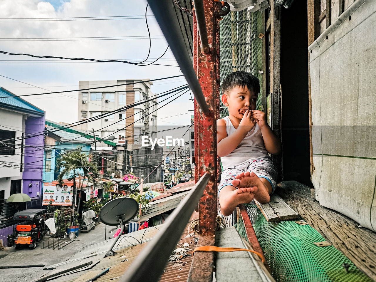 Side view of young woman sitting on street