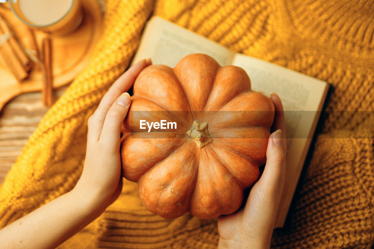 CROPPED IMAGE OF PERSON HOLDING PUMPKIN