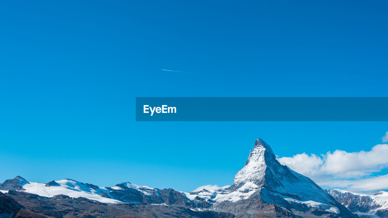 Scenic view of snowcapped mountains against clear blue sky, matterhorn, switzerland 