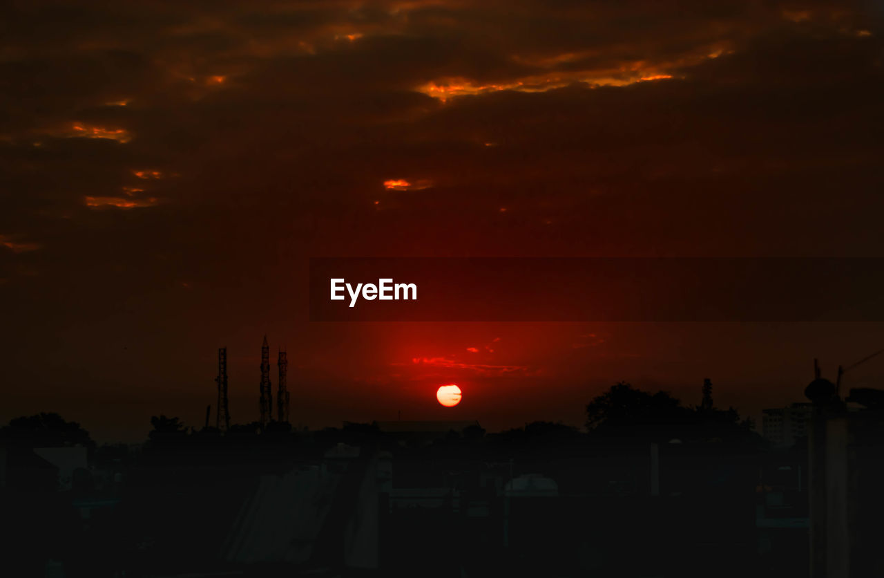 SILHOUETTE OF BUILDINGS AGAINST DRAMATIC SKY