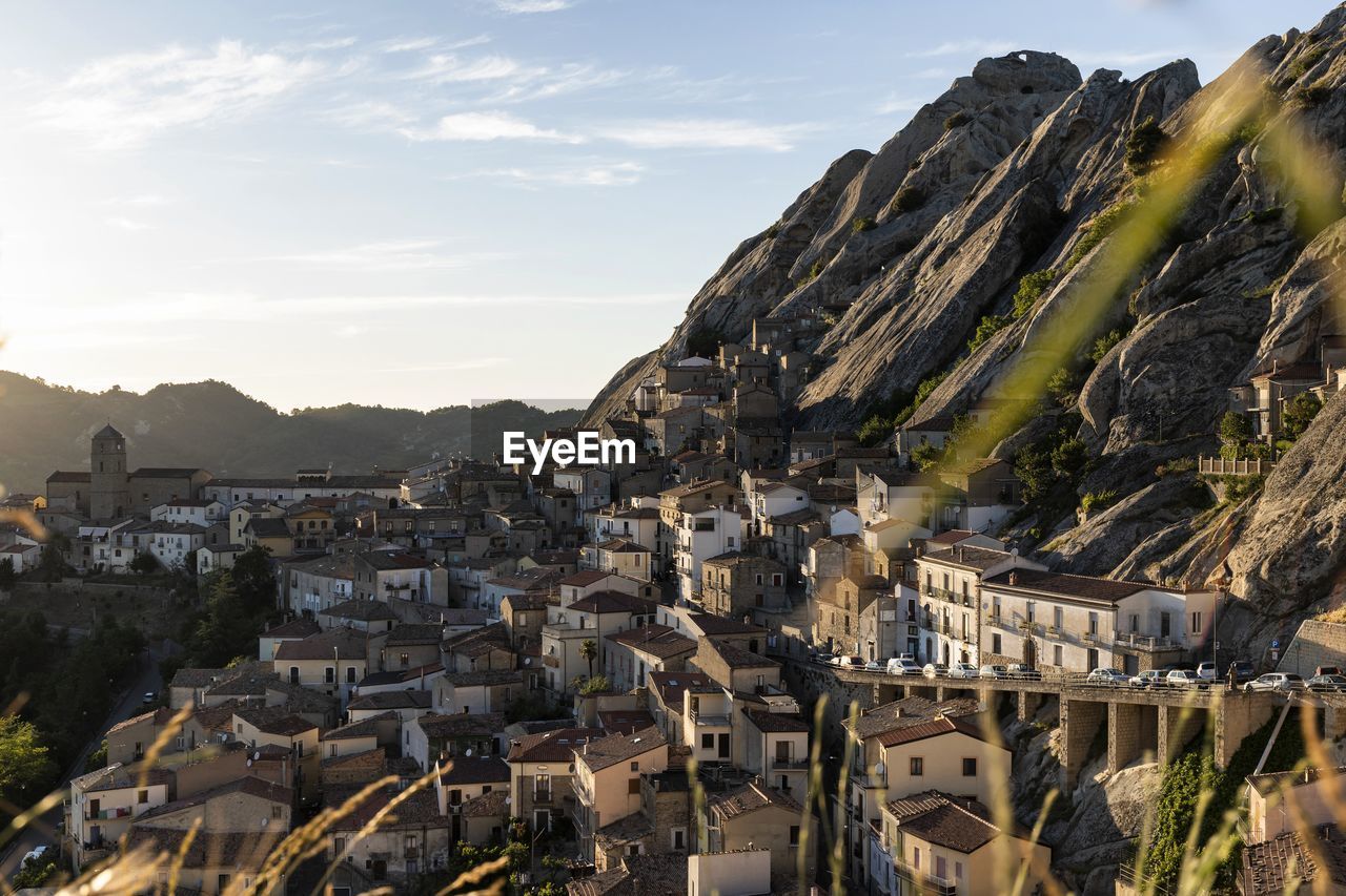 AERIAL VIEW OF TOWN BY MOUNTAINS AGAINST SKY