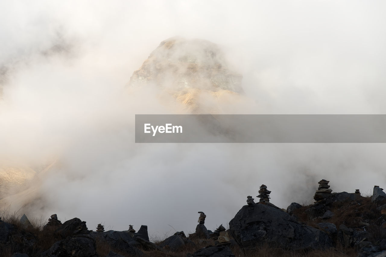 Panoramic view of foggy mountain against sky