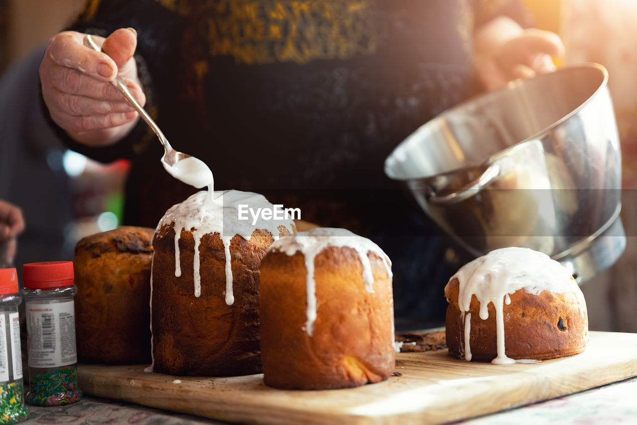 food and drink, food, dessert, freshness, baked, hand, sweet food, meal, one person, indoors, bread, produce, table, healthy eating, wood, sweet, adult, preparing food, kitchen utensil, cake, celebration, focus on foreground, close-up