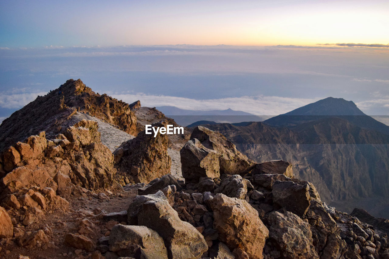 Rock formations above the clouds against sky during sunrise at mount meru 
