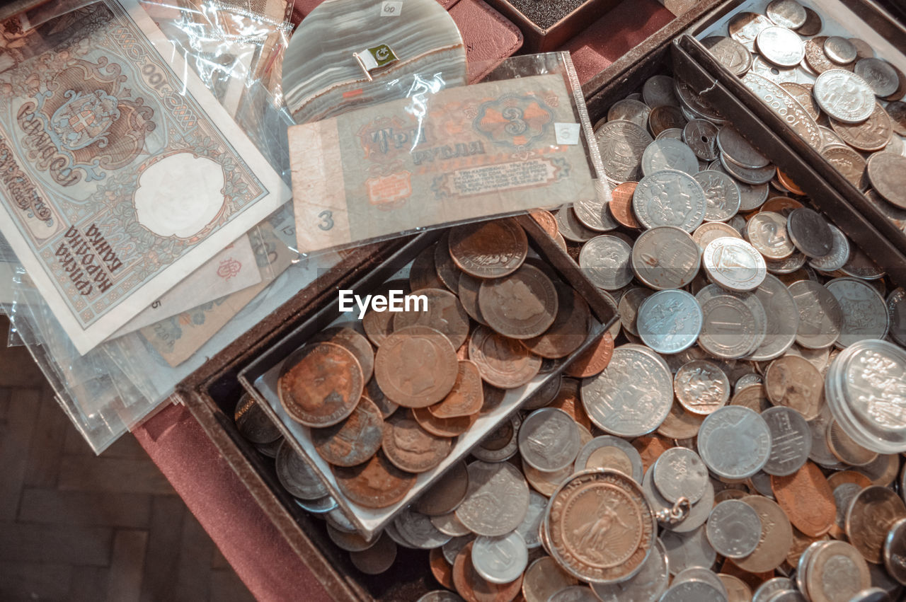 Old coins and paper money are lying on the edge of the table. top view