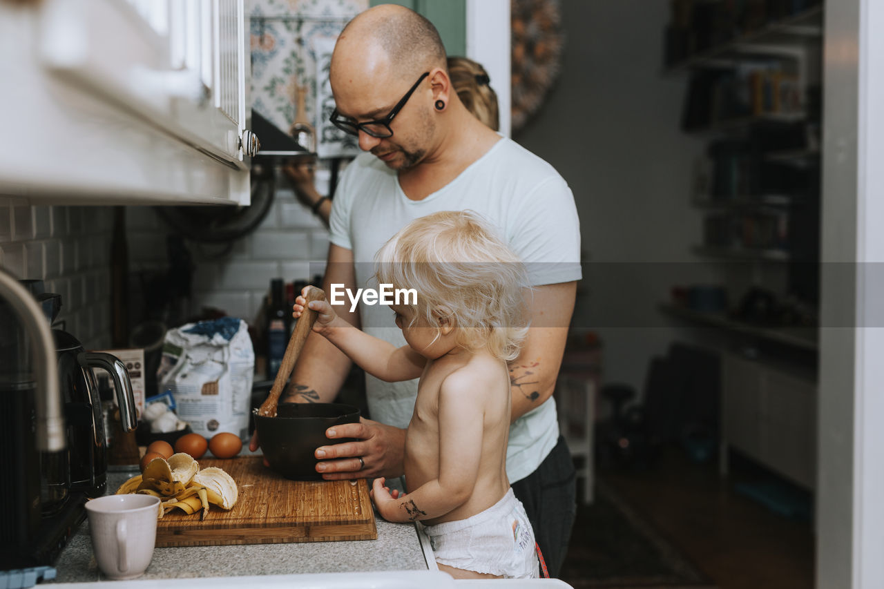 Father with toddler preparing food