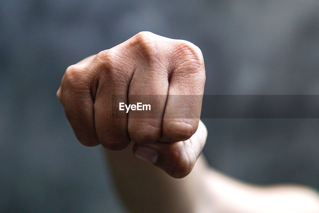 Cropped image of hand clenching fist