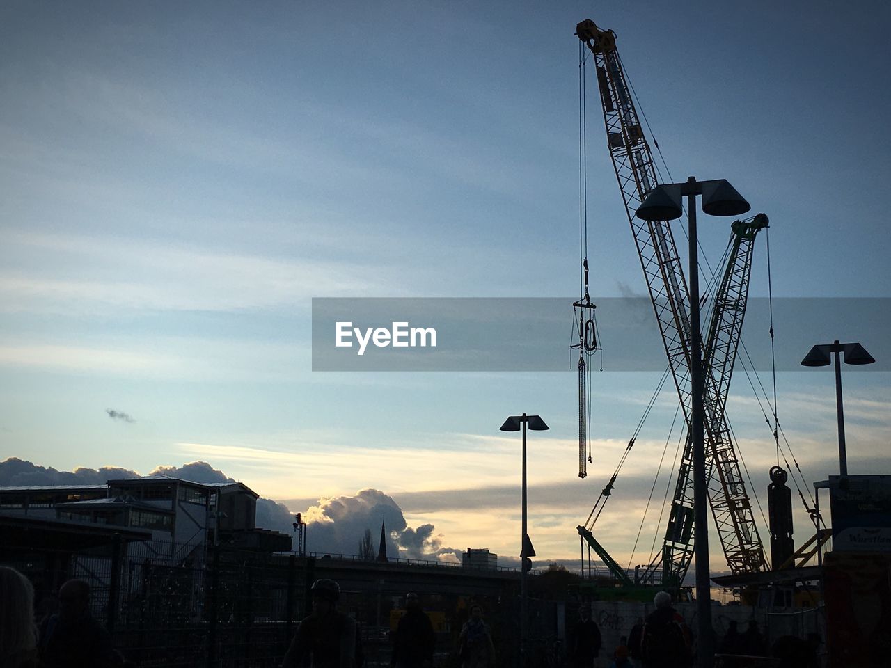 SILHOUETTE CRANES AGAINST SKY