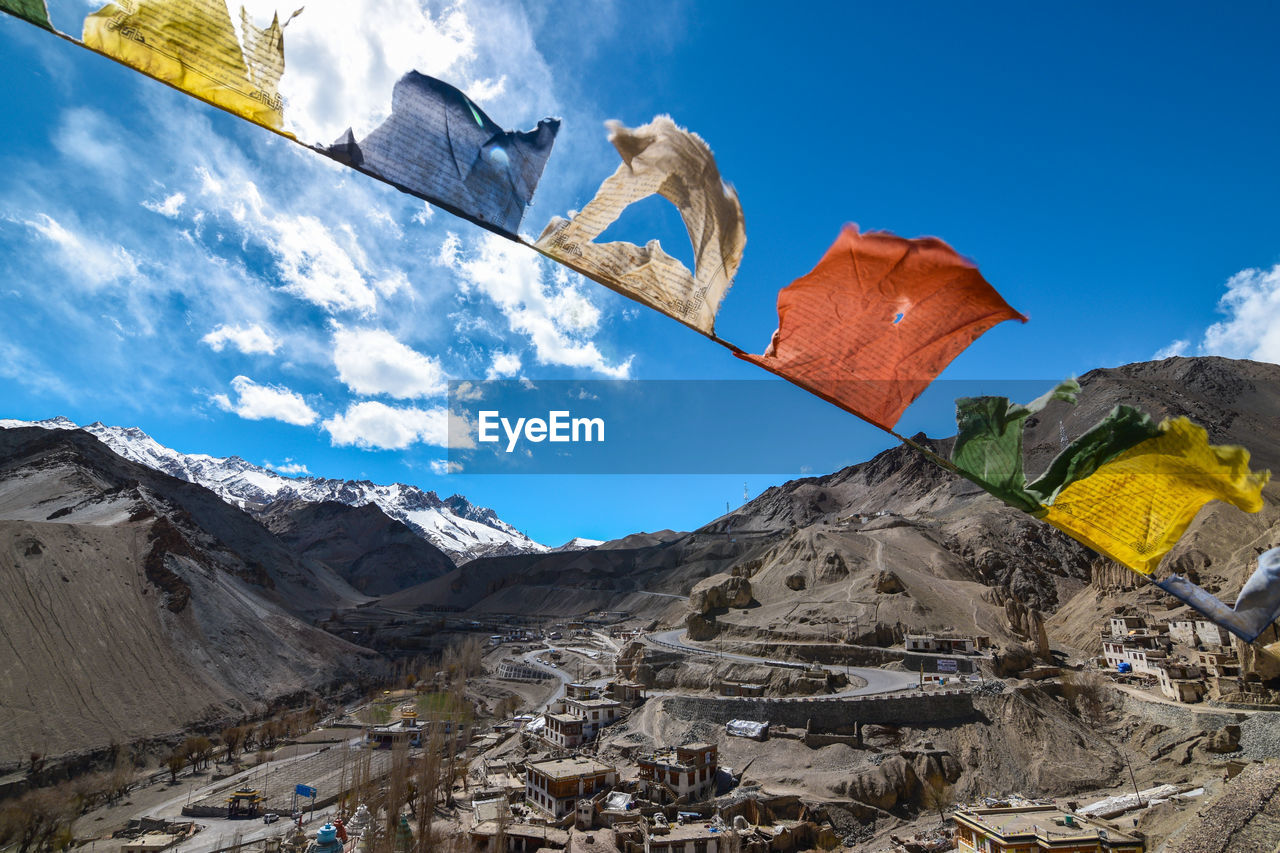 Colorful prayer flags hanging against mountains and sky