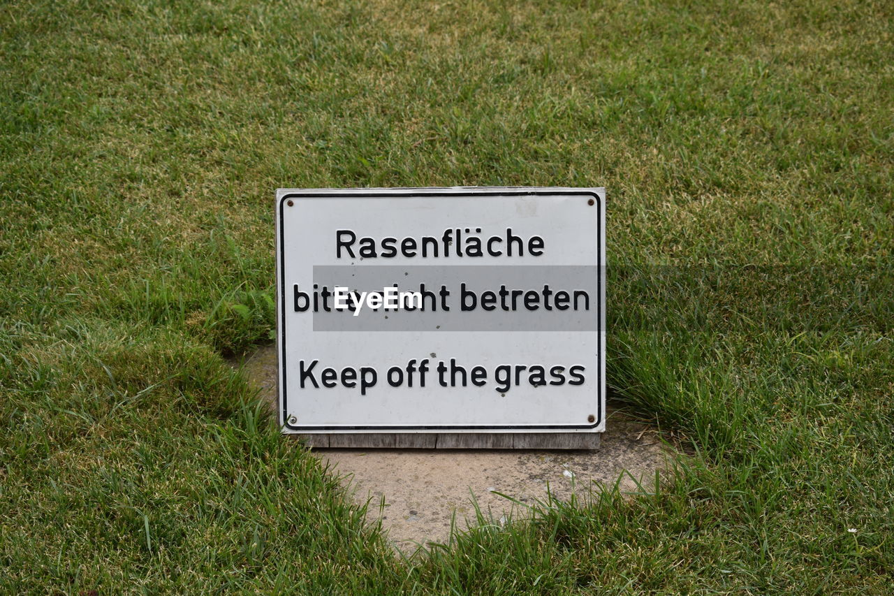 CLOSE-UP OF SIGNBOARD ON GRASS