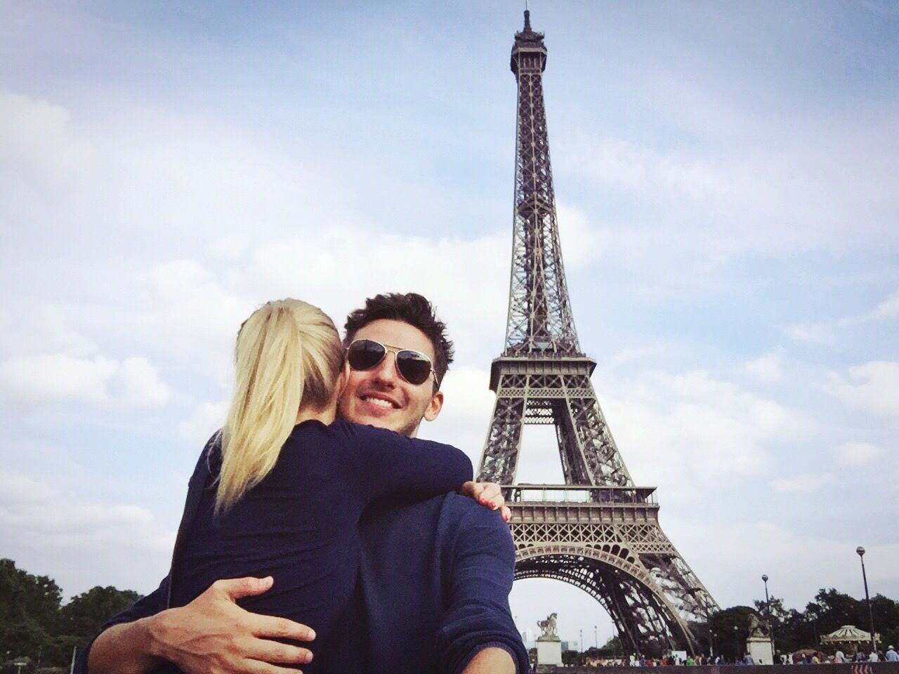 Young couple hugging with eiffel tower against sky in background