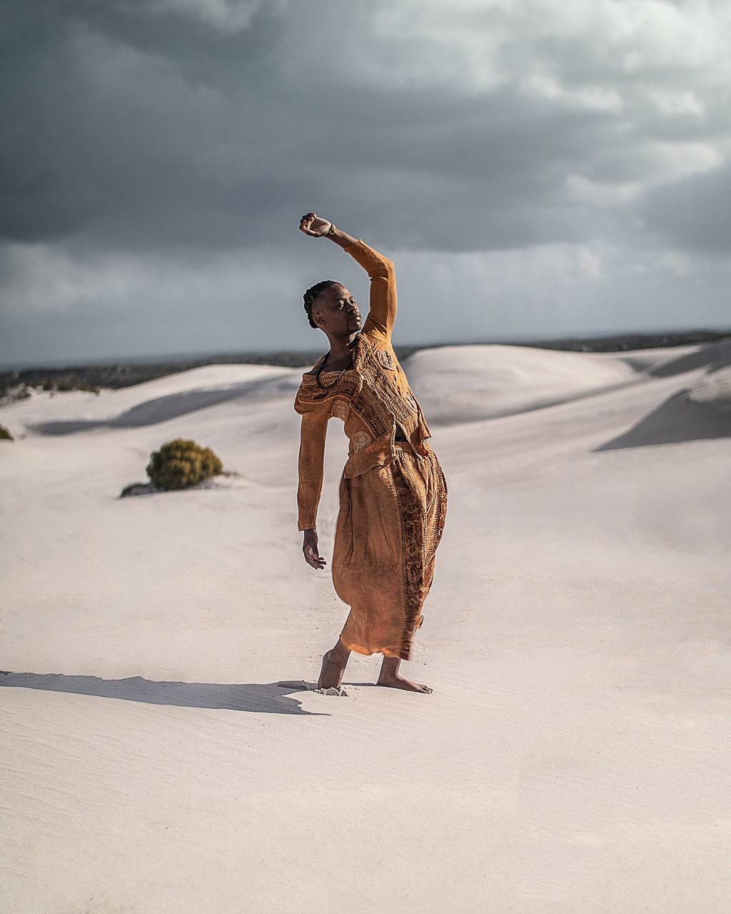 Full length of young man wearing traditional clothing standing at desert