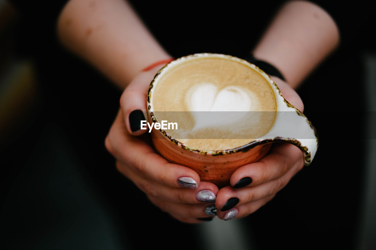 CLOSE-UP OF HAND HOLDING COFFEE