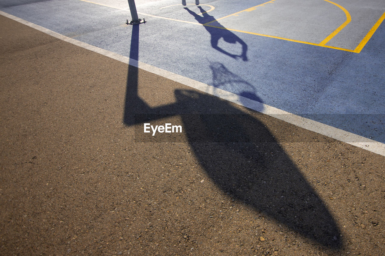 High angle view of shadow of man playing basketball at court