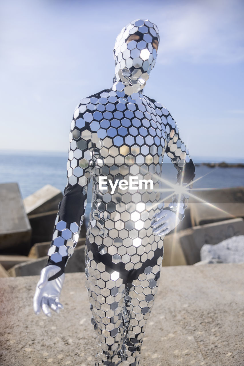 Man wearing shiny costume against sky