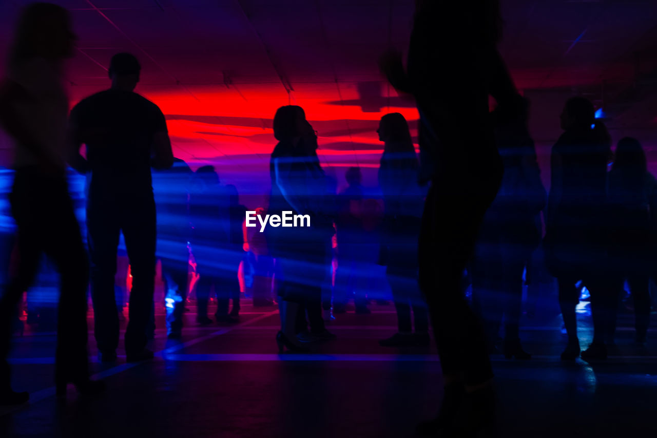 Silhouette people in illuminated nightclub
