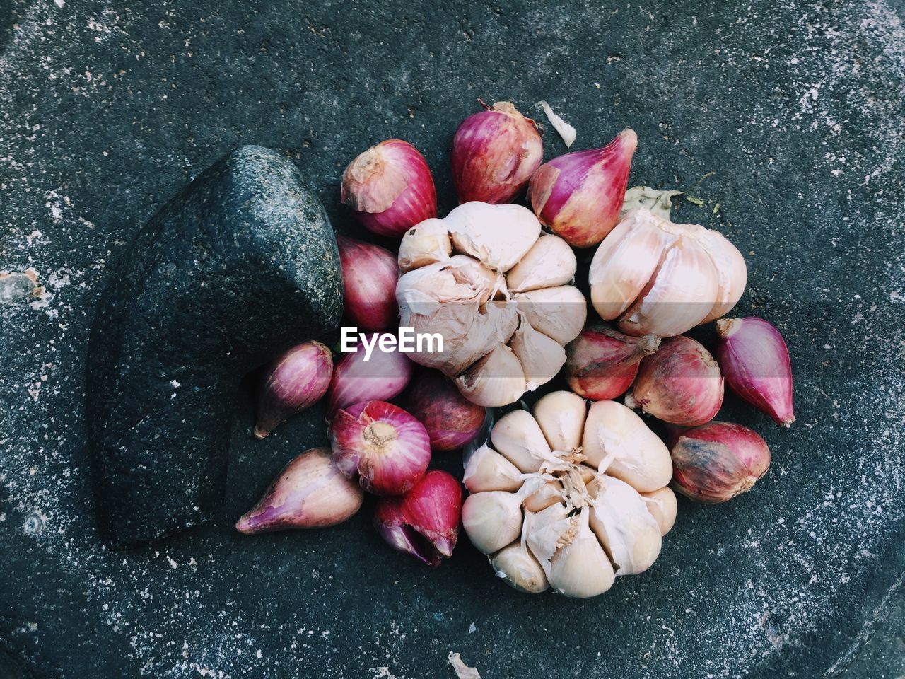 High angle view of garlic and onions on mortar