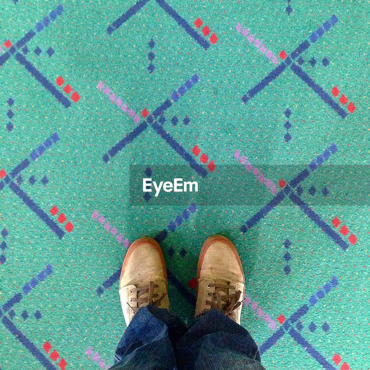 Low section of man standing on carpet at airport