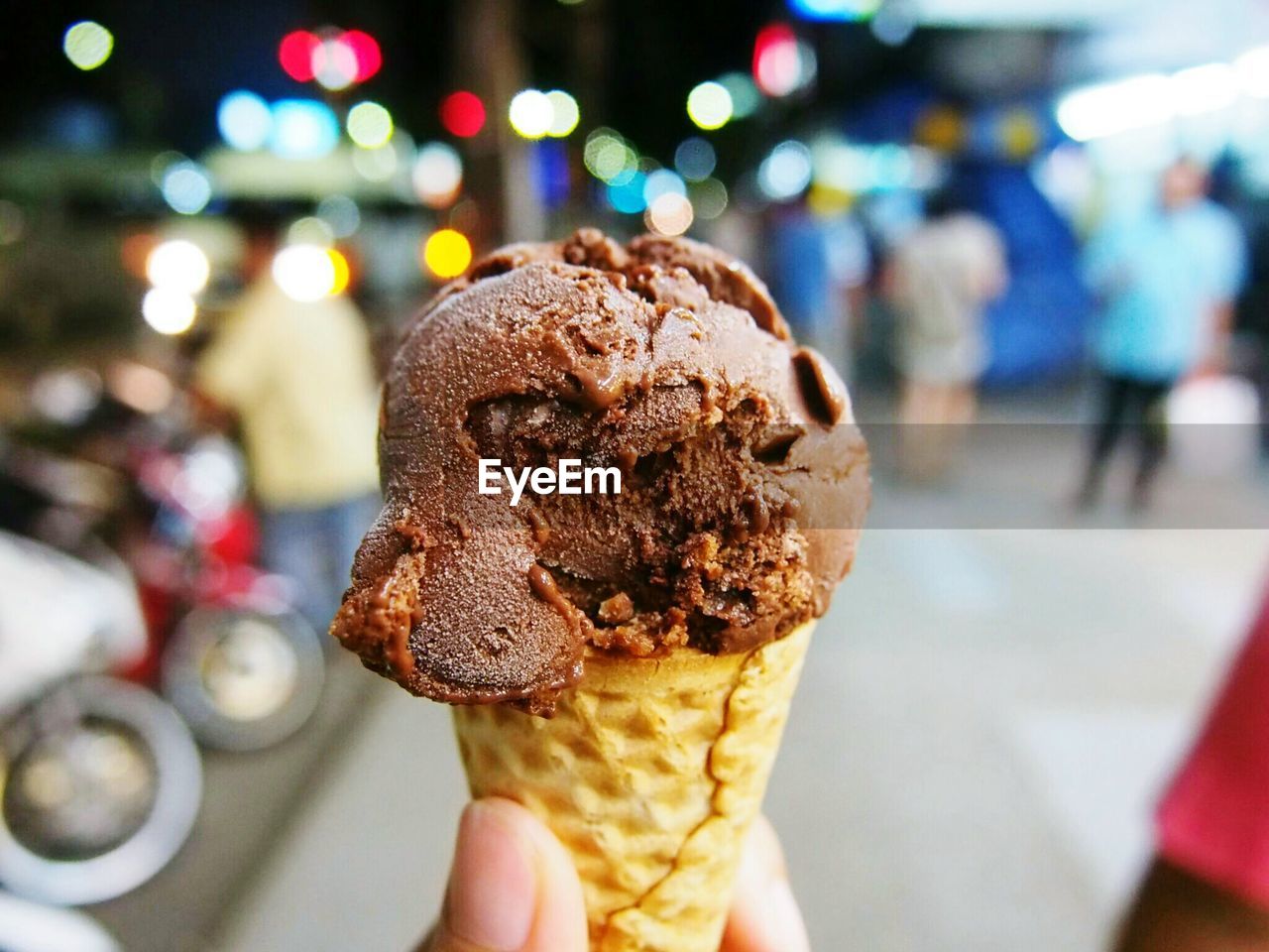 Close-up of person hand holding chocolate ice cream cone