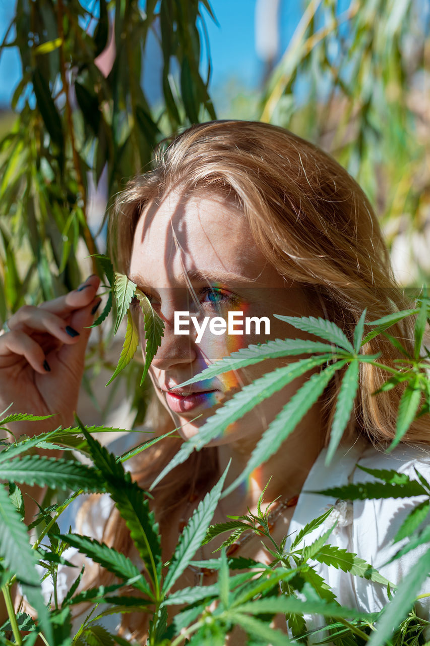 Woman looking away while holding plant