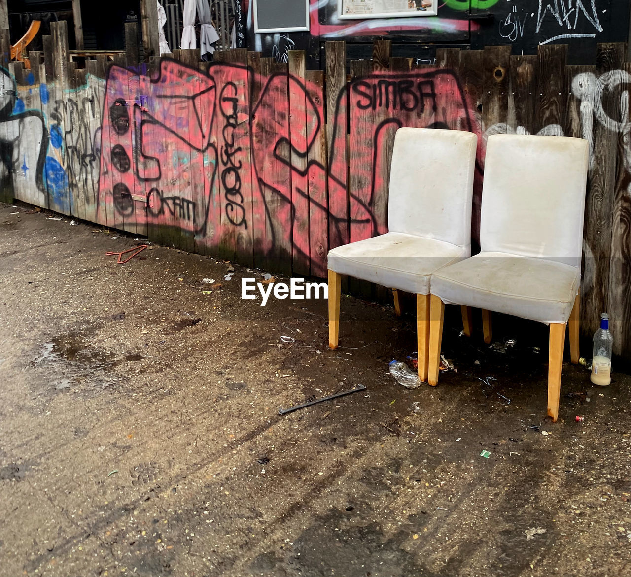 graffiti, seat, architecture, no people, city, urban area, chair, creativity, day, built structure, street, wall - building feature, art, empty, street art, building exterior, outdoors, abandoned, absence, footpath