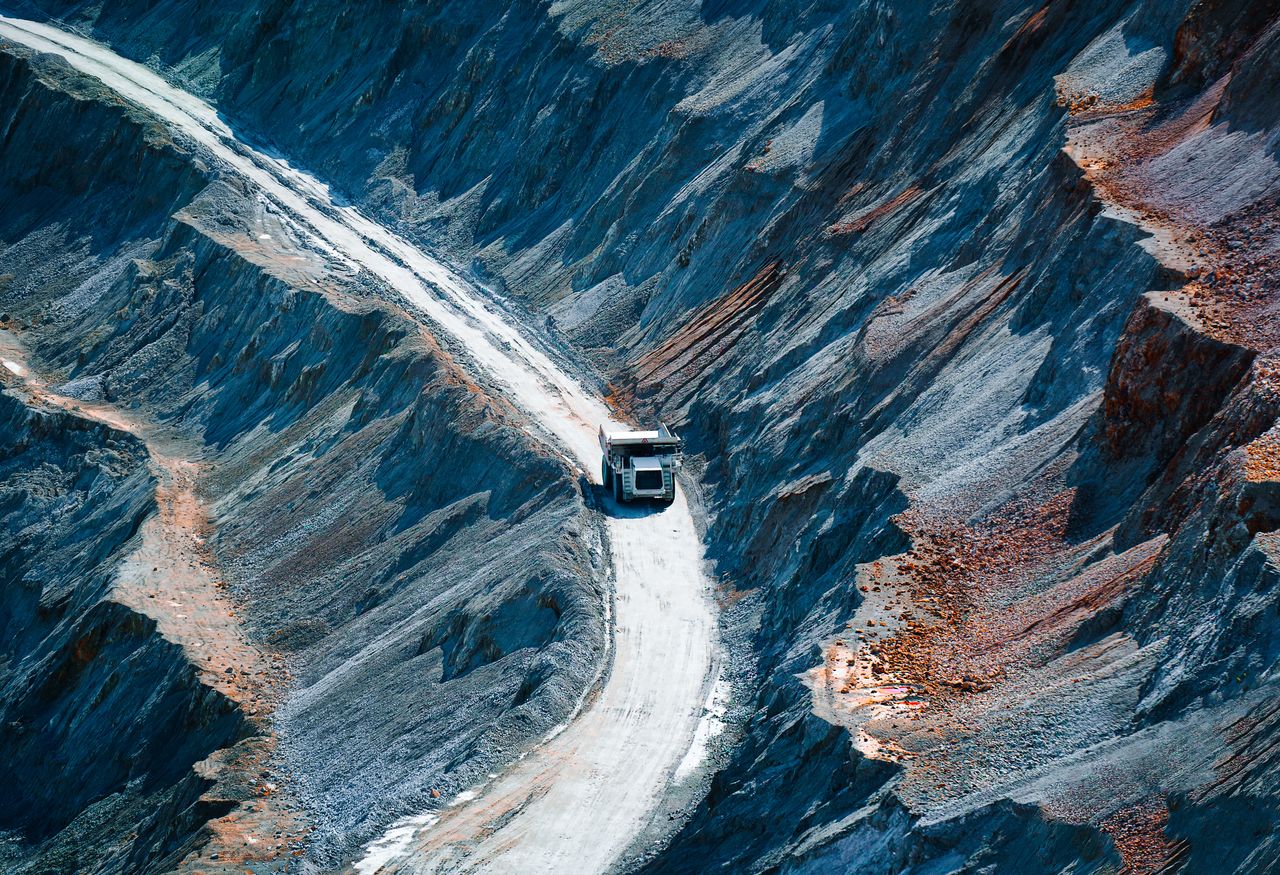 High angle view of mining vehicle road amidst rock formation in open pit mine
