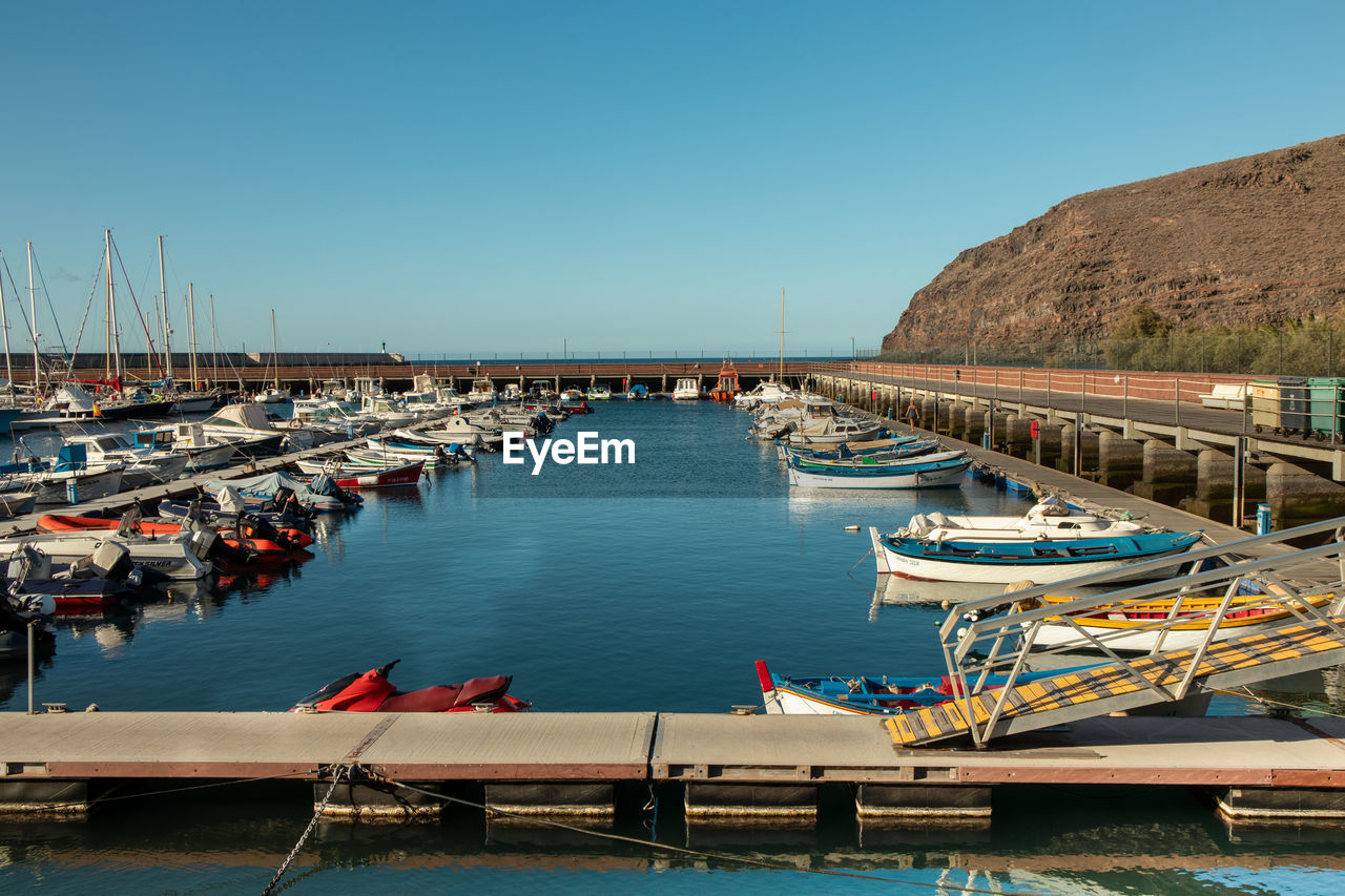 BOATS MOORED AT HARBOR