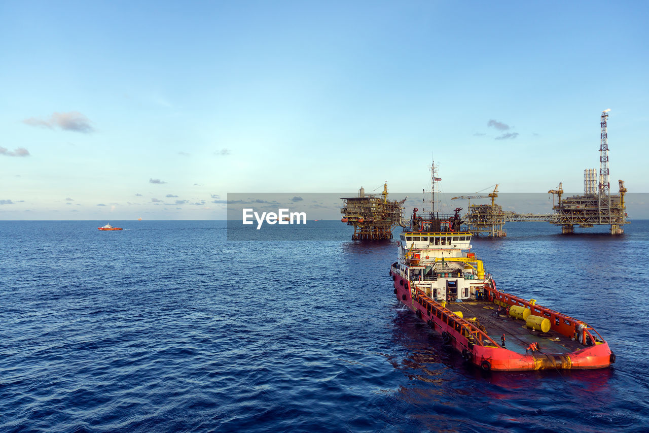An anchor handling tugboat maneuvering near an offshore oil production platform at oil field