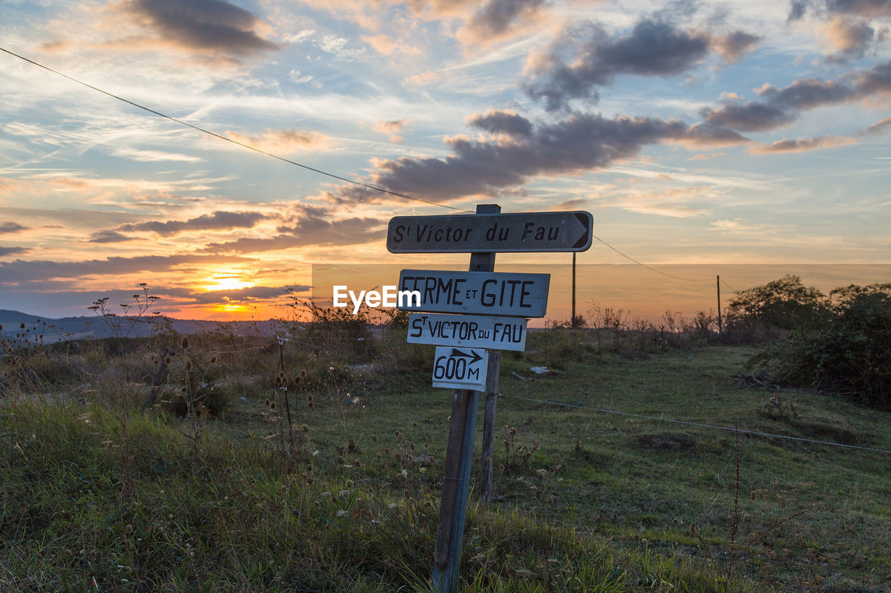 INFORMATION SIGN ON FIELD AGAINST SKY