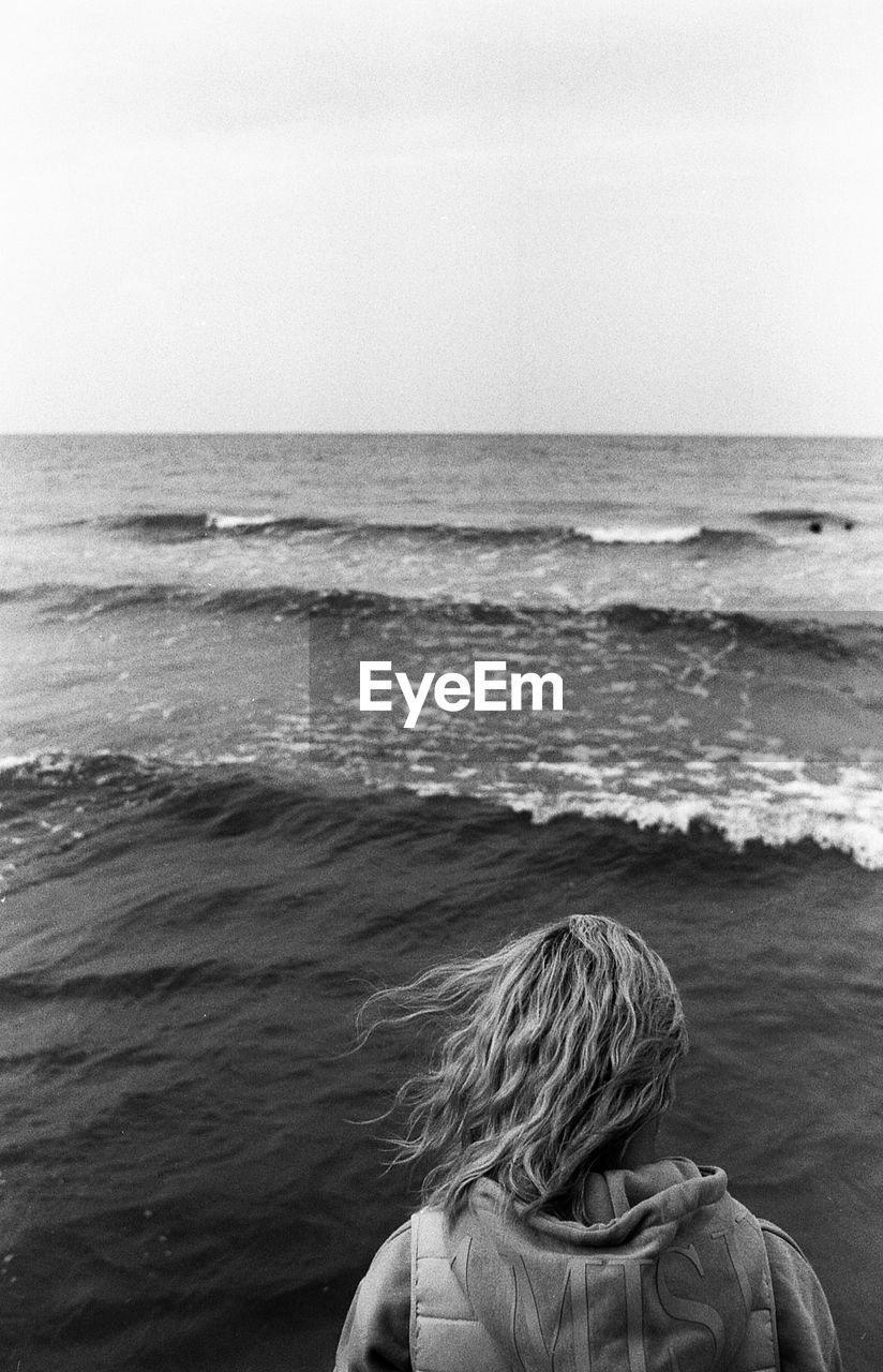 Rear view of woman looking at sea against sky