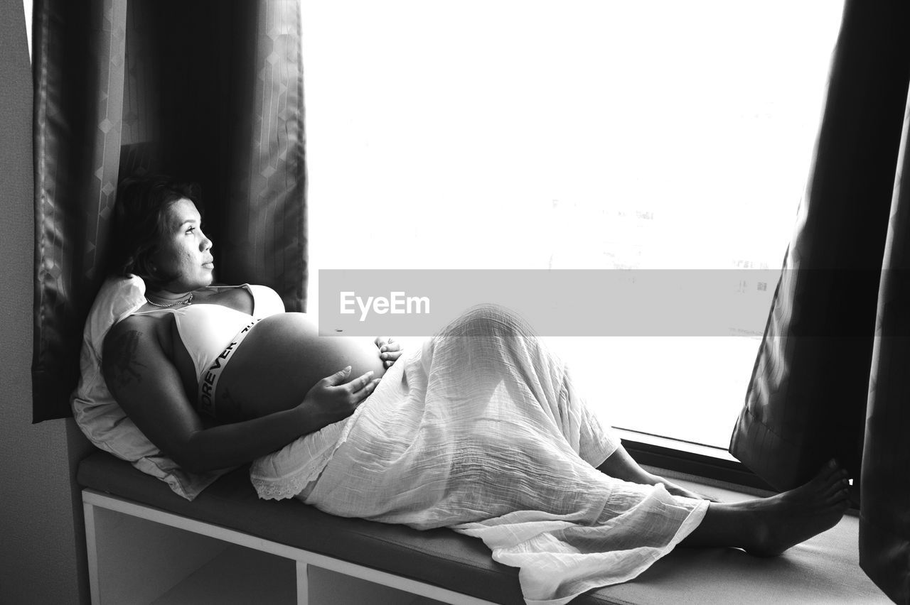 Pregnant woman sitting by window
