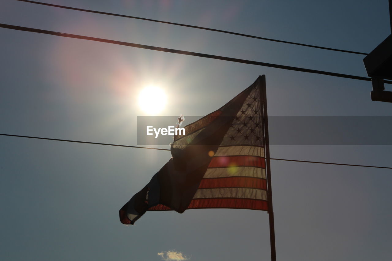 Silhouette of american flag hanging on rope