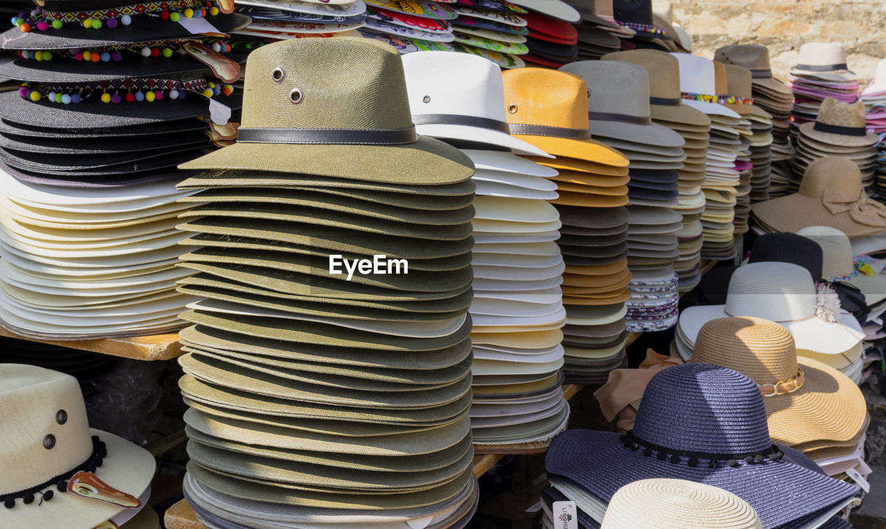 Stack of multi colored hats for sale at market stall