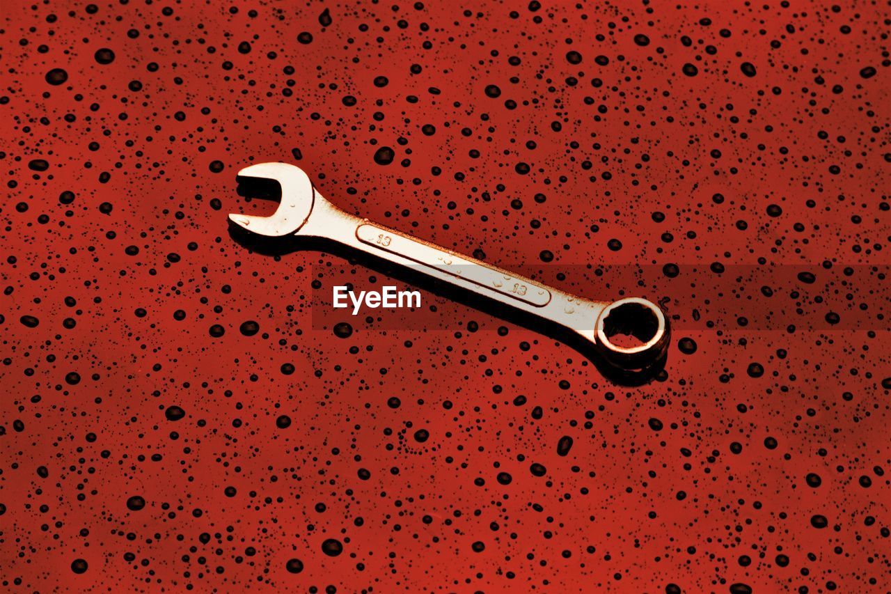 Close-up of wrench on red abstract background
