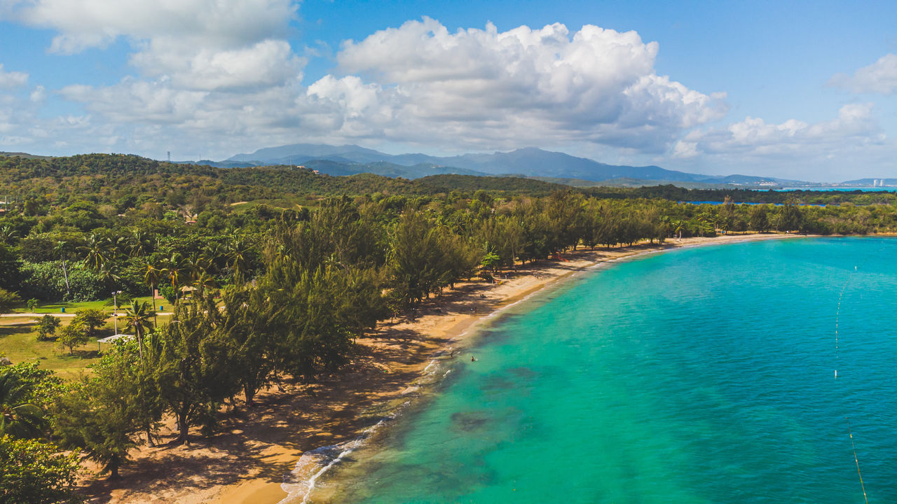 scenic view of sea and mountains against sky