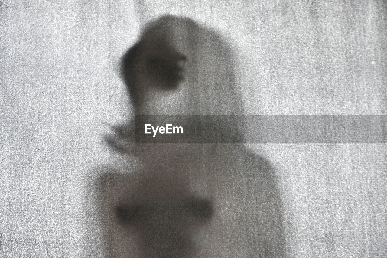 Shadow of woman on curtain at home