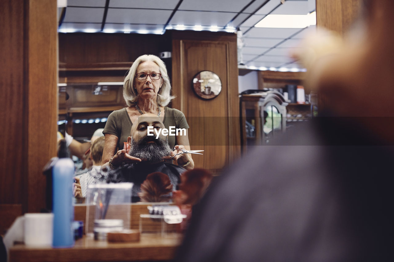 Woman Cutting Bald Man Beard In Hair Salon On Eyeem
