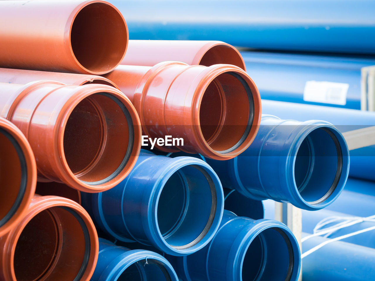 Close-up of stack of blue and brown plastic pipes 
