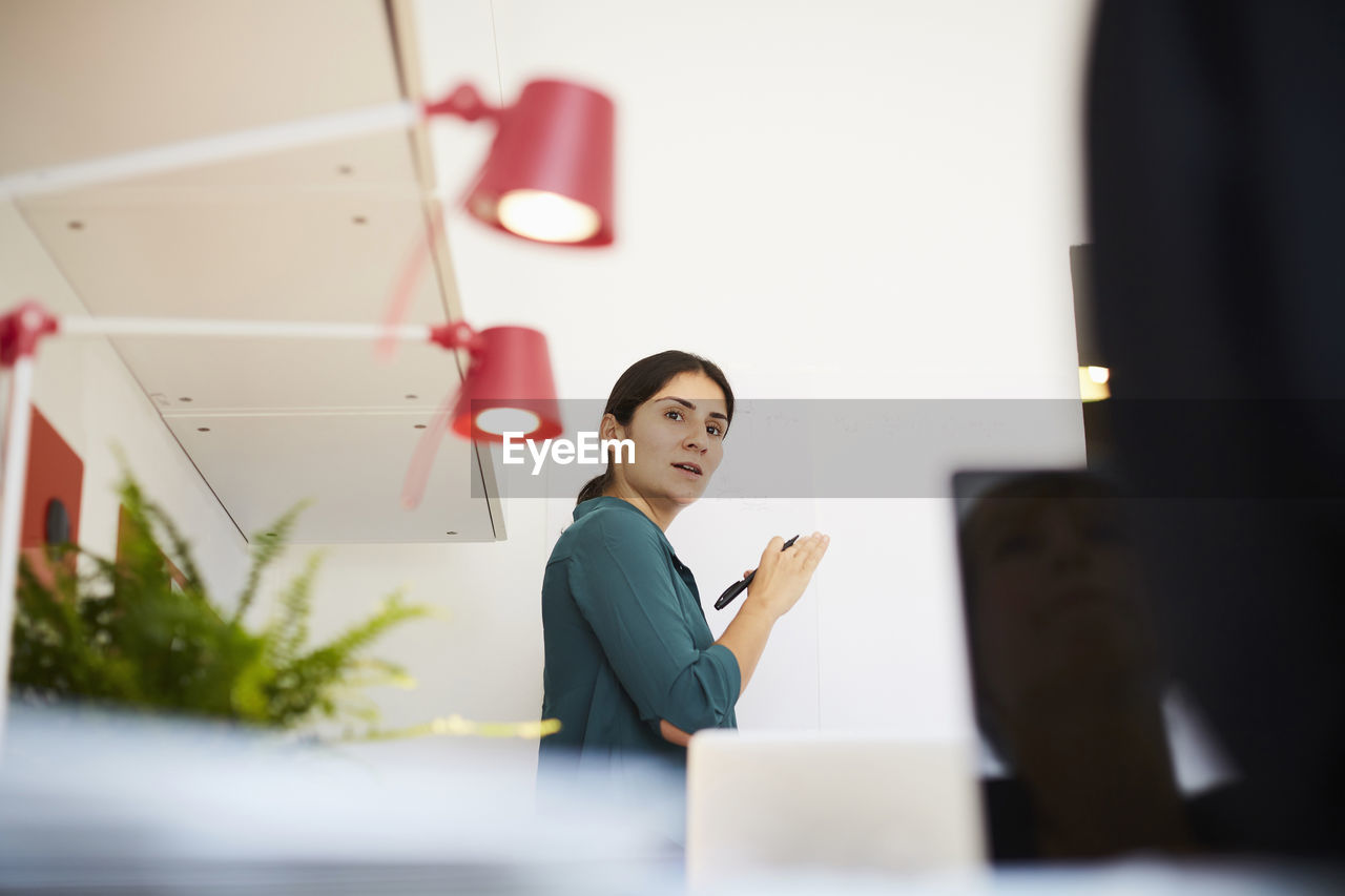 Low angle view of businesswoman discussing with female colleague in office