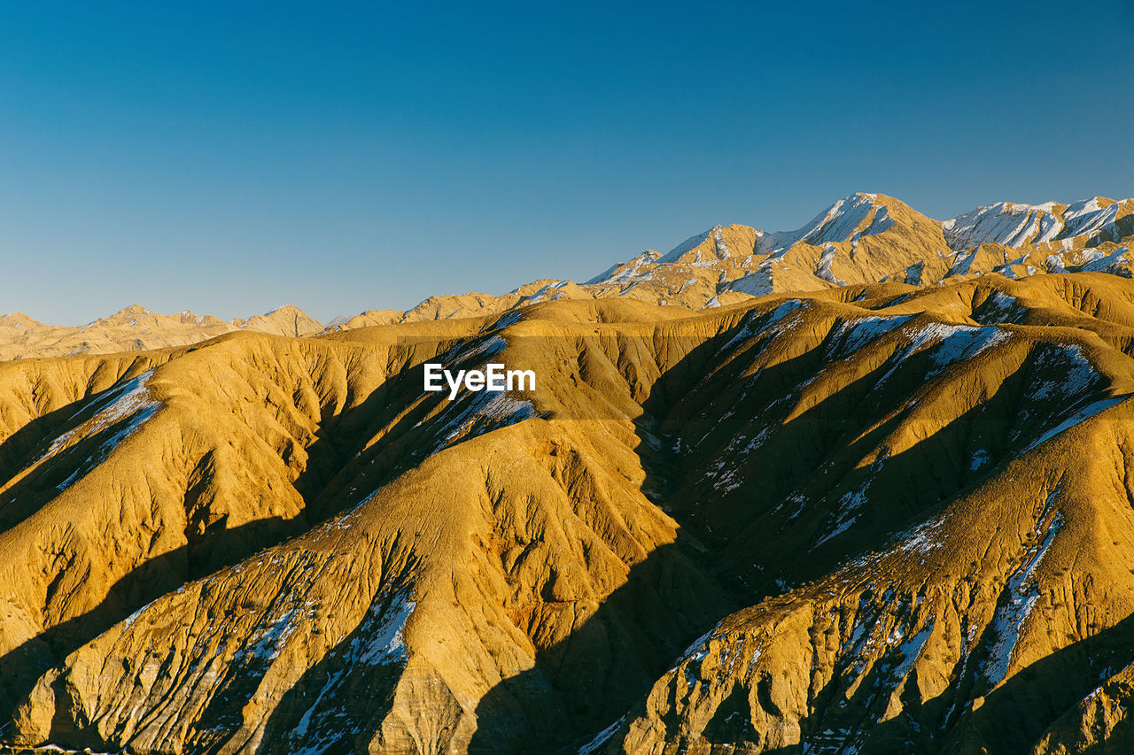 Scenic view of mountain range against clear blue sky