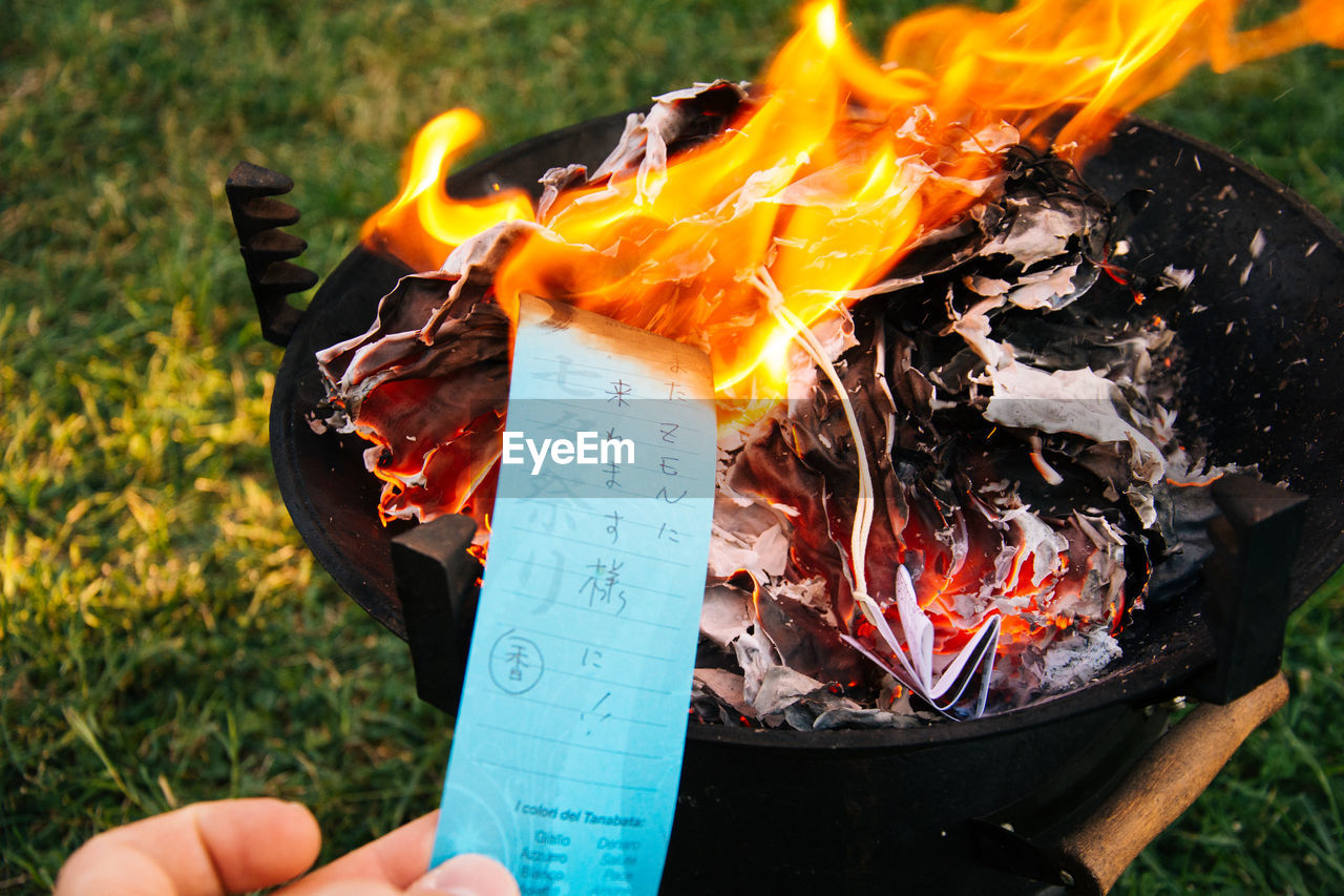 Close-up of person burning papers